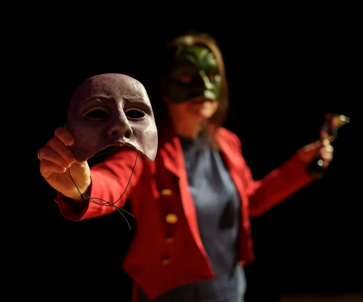 Photo of one of the Geese team members raising a half mask to the camera